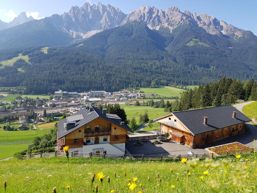 a village in a valley with mountains in the background at Ferienwohnungen Kuentnerhof in San Candido