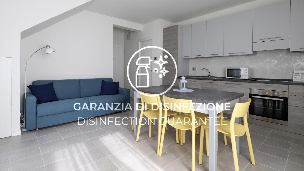 una cucina con divano blu, tavolo e sedie di Italianway - Giuseppe Pastine 17/D a Santa Margherita Ligure