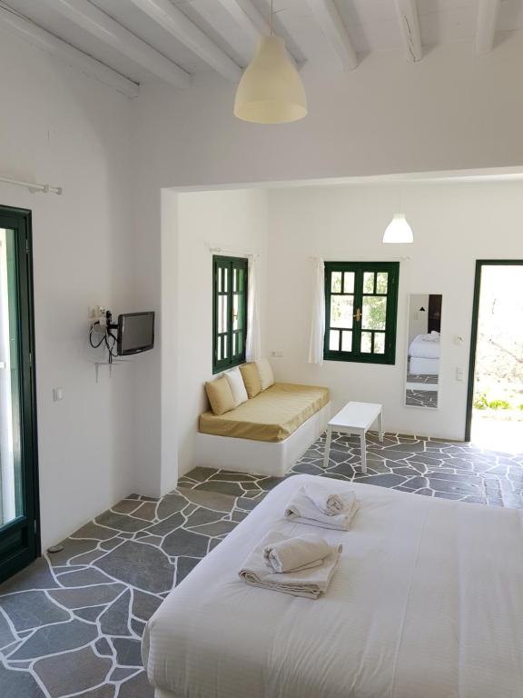 a white room with a bed and a couch at Andromeda in Exámbela