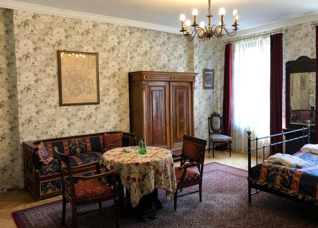 Austeria Klezmer Hois في كراكوف: غرفة معيشة مع طاولة مع كراسي وسرير