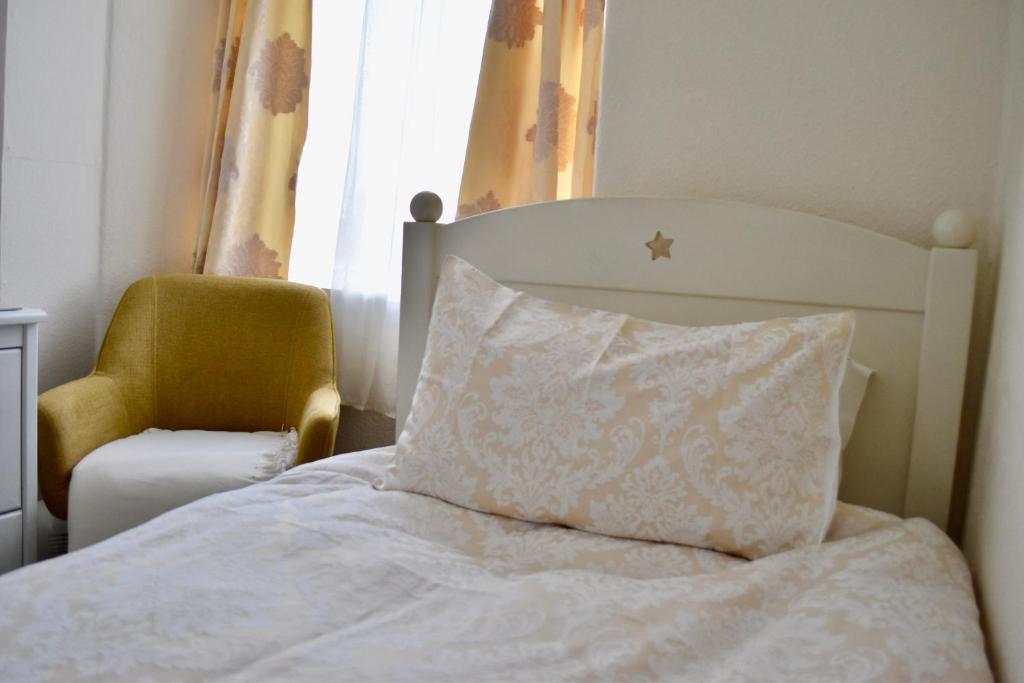 a bed with a pillow and a chair in a room at Witchingham B&B in Holyhead