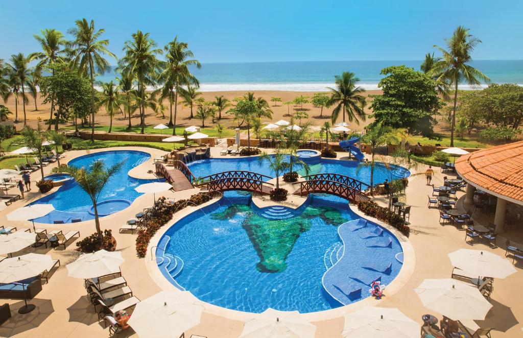 an overhead view of a resort pool with the beach at Crocs Resort & Casino in Jacó