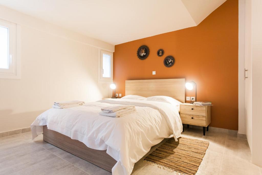 - une chambre avec un grand lit et un mur orange dans l'établissement Walk through Athens, based in a local’s hip house!, à Athènes