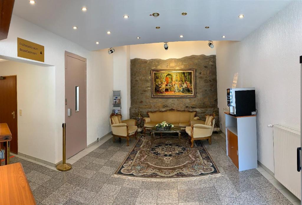 a living room with a couch and a painting on the wall at Hotel Erlenbacher Hof in Bad Homburg vor der Höhe