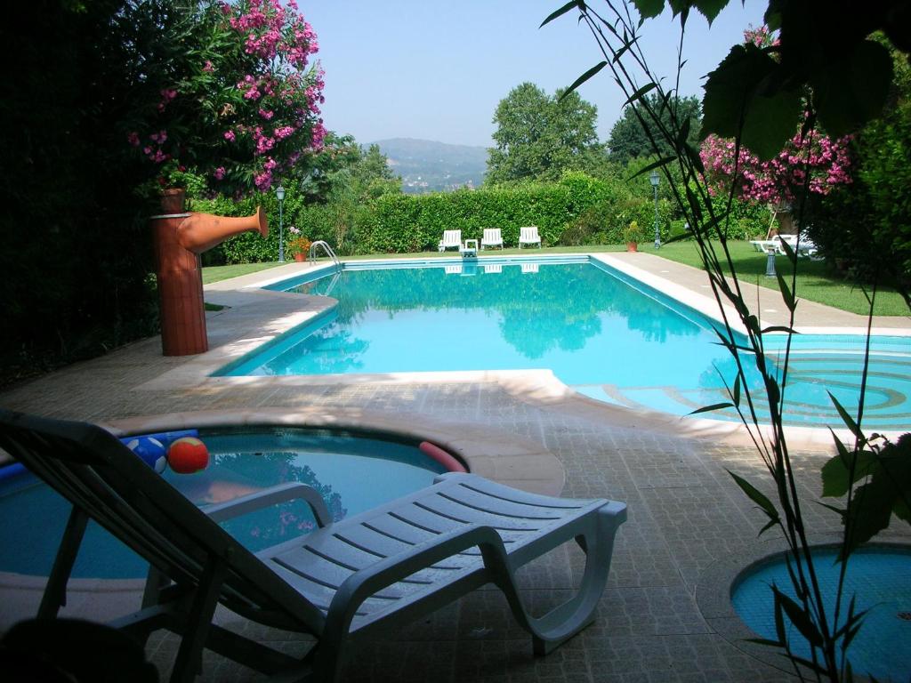 uma piscina com uma cadeira ao lado de uma cadeira em 2 bedrooms villa with shared pool jacuzzi and enclosed garden at Pedraca em Pedraça