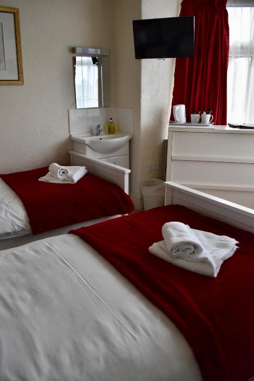a bedroom with a bed with towels on it at Witchingham B&B in Holyhead