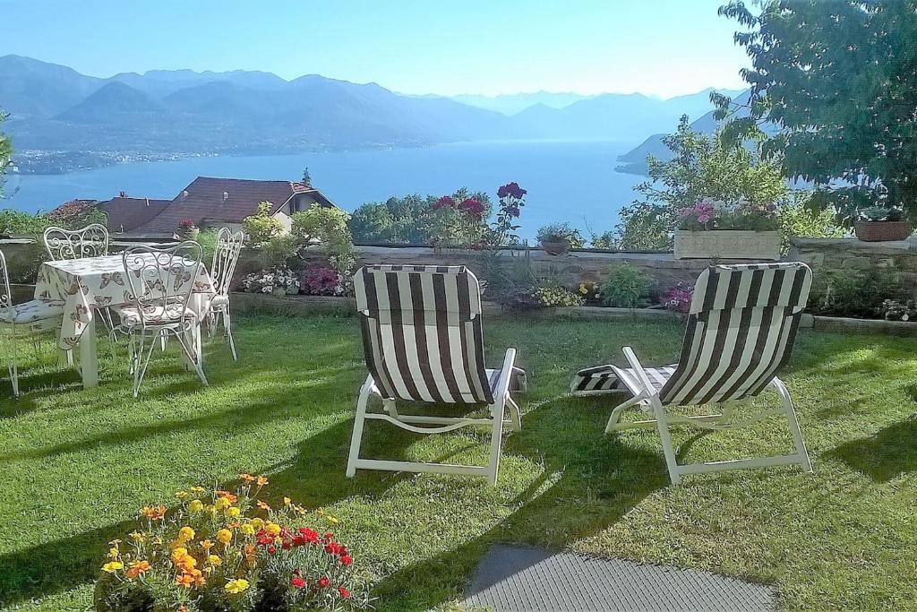 two chairs and a table on a lawn with a view at LA CASA DI MONICA E LUCIANO in Stresa