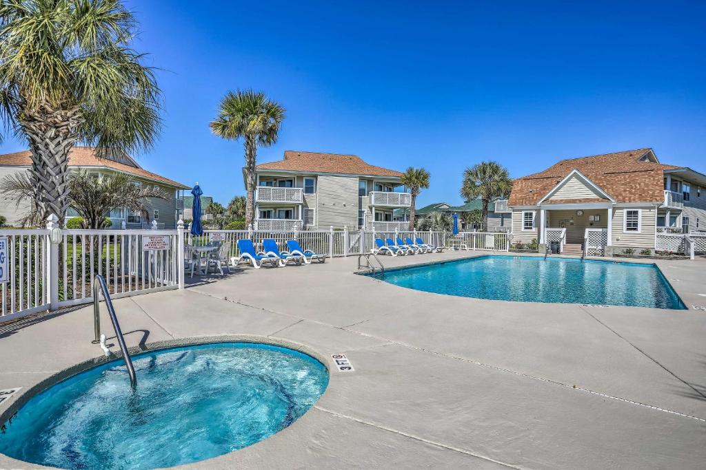a swimming pool at a resort with chairs and trees at Walk to Beach North Myrtle Condo! in Myrtle Beach