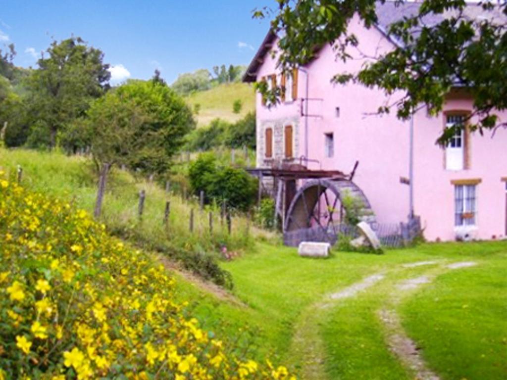 a pink house on a hill next to a field of flowers at Maison de 2 chambres avec jardin clos et wifi a Chirens in Chirens