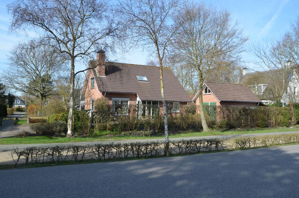 een huis met een bruin dak op een straat bij De strandkamer in Oostkapelle