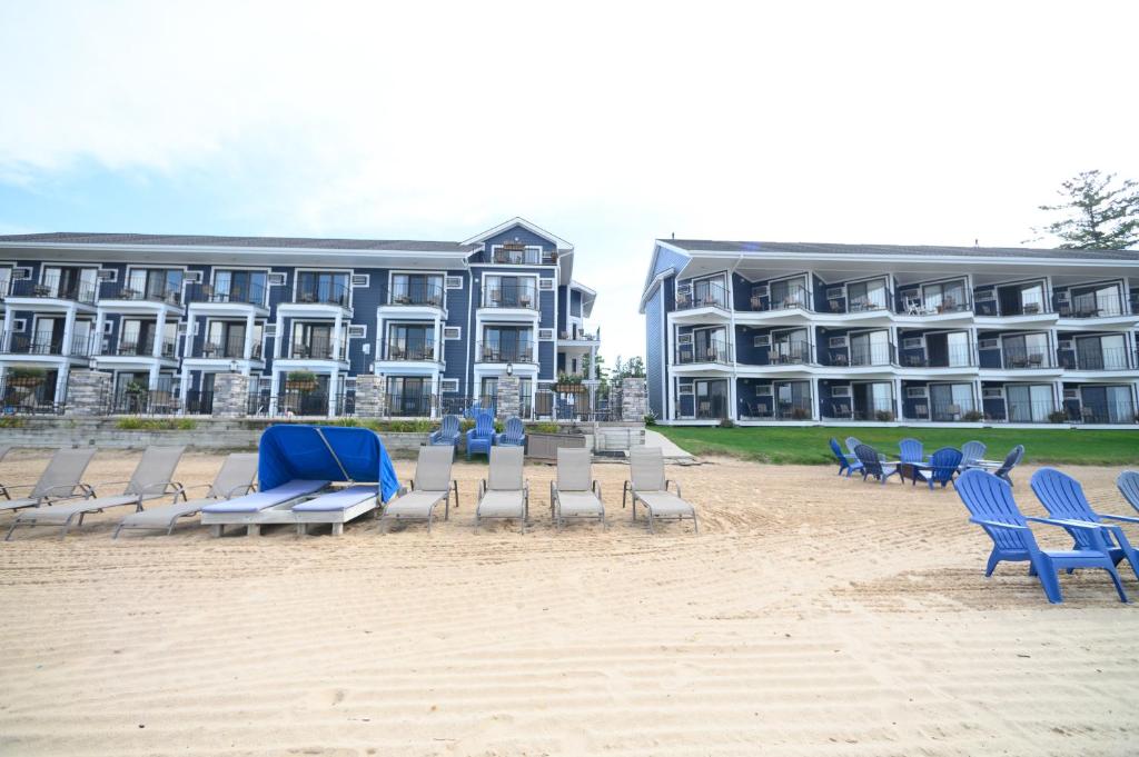 a row of chairs and chairs on the beach in front of a hotel at Pointes North Beachfront Resort Hotel in Traverse City