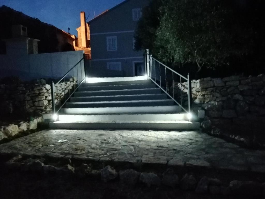 um conjunto de escadas com luzes à noite em Country House em Čunski