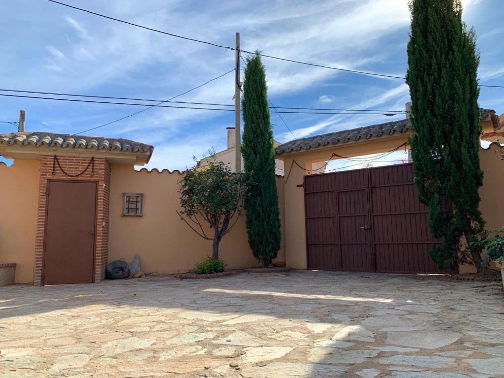 a house with a garage and two trees at 3 bedrooms house with enclosed garden and wifi at Aldehuela de la Boveda in Aldehuela de la Bóveda