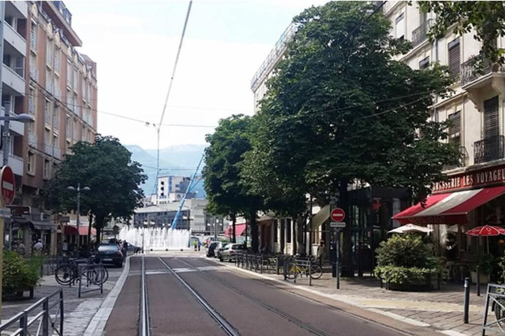 an empty city street with parked cars and buildings at joli 2 pieces en centre ville , gare à 50 mètres in Grenoble