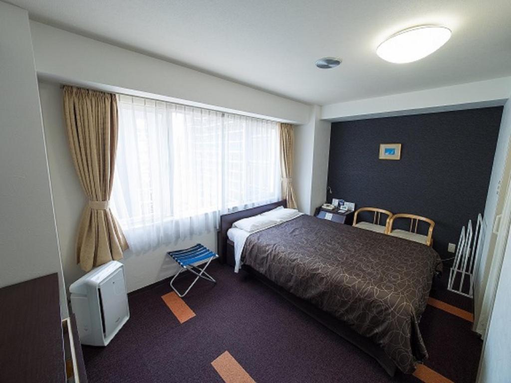 a hotel room with a bed and a window at Hotel Shin Osaka / Vacation STAY 81523 in Osaka
