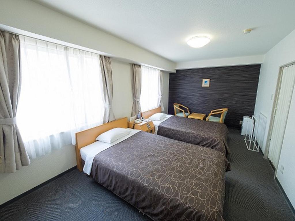 a hotel room with two beds and a window at Hotel Shin Osaka / Vacation STAY 81542 in Osaka