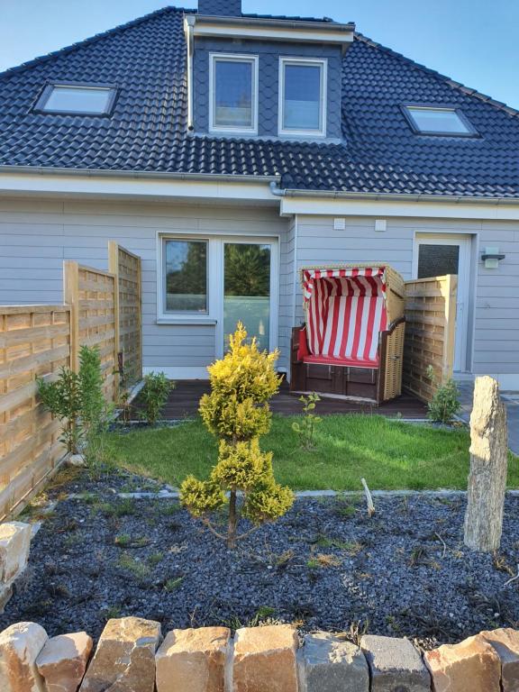 Una casa con un banco con una bandera americana. en Nordsee-Pension Dagebüll, en Dagebüll