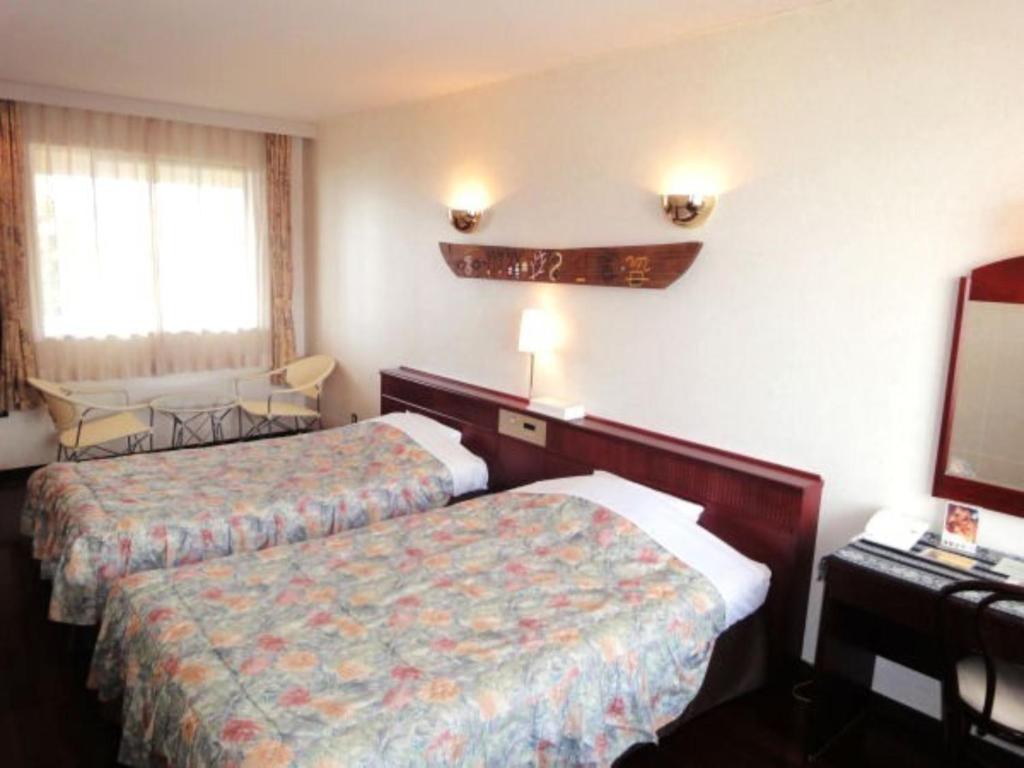 a hotel room with two beds and a television at Amami Resort Bashayamamura / Vacation STAY 81479 in Amami