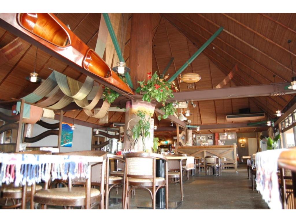 ein Restaurant mit Tischen und Stühlen sowie Surfbrettern an der Decke in der Unterkunft Amami Resort Bashayamamura / Vacation STAY 81484 in Amami