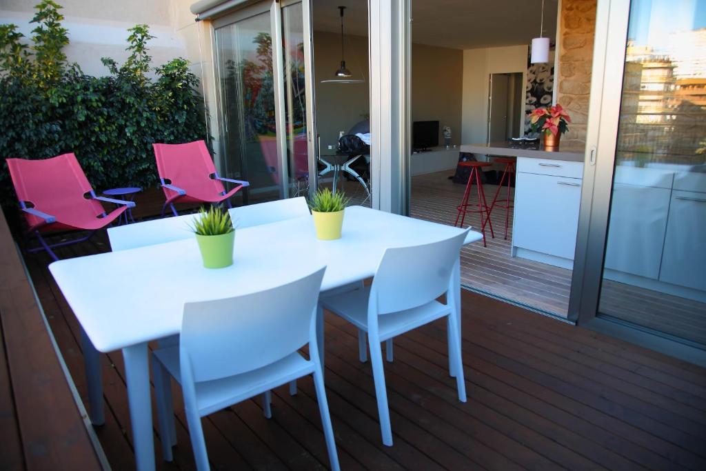 einen weißen Tisch und Stühle auf einer Terrasse in der Unterkunft Apartamentos Alfonso X in Alicante