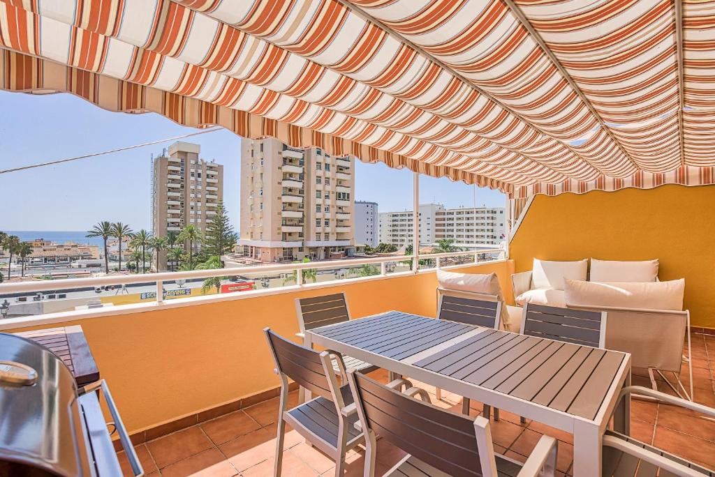 a patio with a table and chairs on a balcony at Sur Suites Torremolinos in Torremolinos