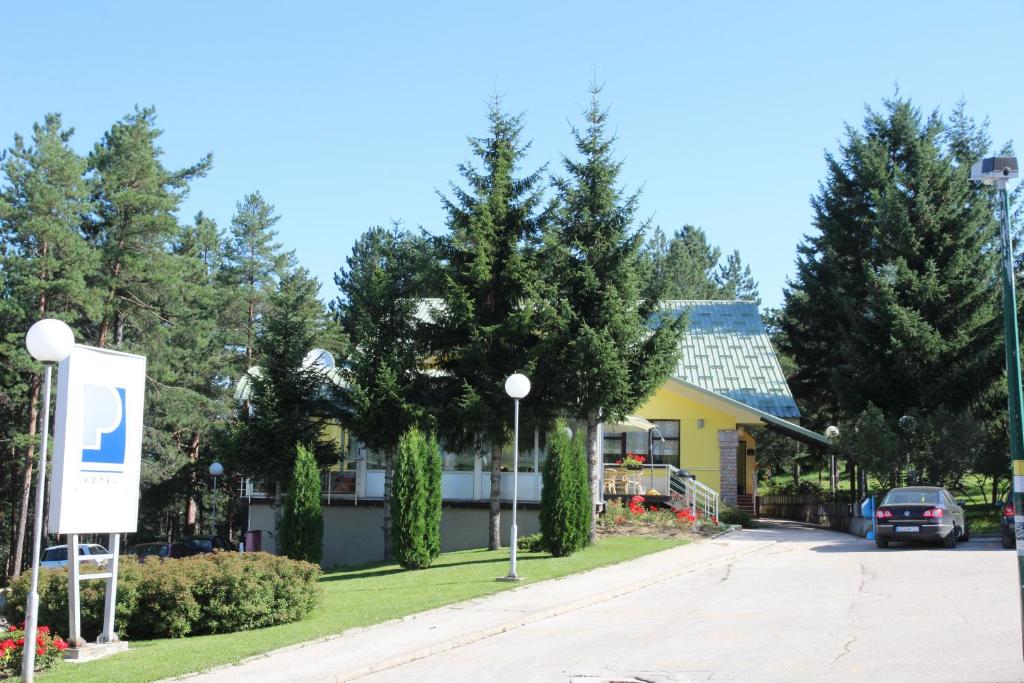 uma casa amarela com um sinal em frente em Hotel President garni em Zlatibor