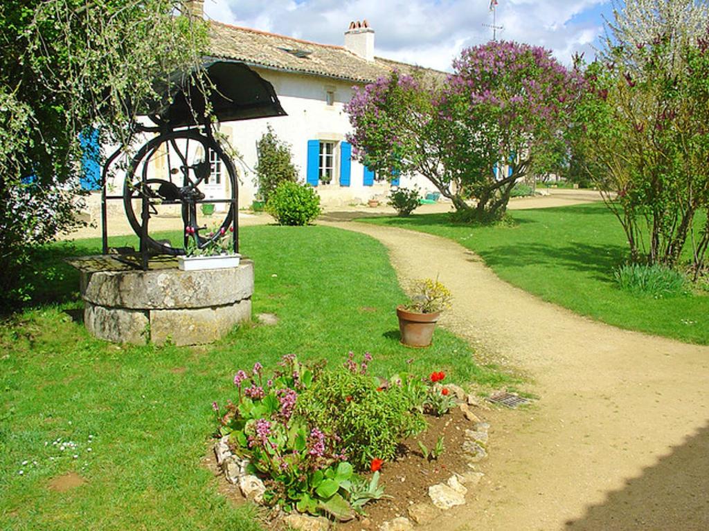 a garden with a wheel in front of a house at Maison de 4 chambres avec piscine partagee jardin amenage et wifi a Saint Vincent la Chatre in Saint-Vincent-la-Châtre