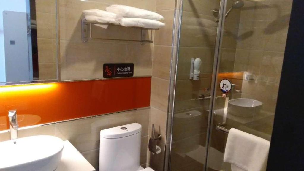 uma casa de banho com um chuveiro, um WC e um lavatório. em 7Days Premium Jinan Shanghe Yujing City Branch em Shang-ho-hsien