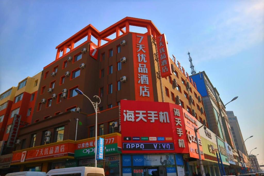 a building with many signs on the side of it at 7Days Premium Gongzhuling Railway Station Branch in Siping