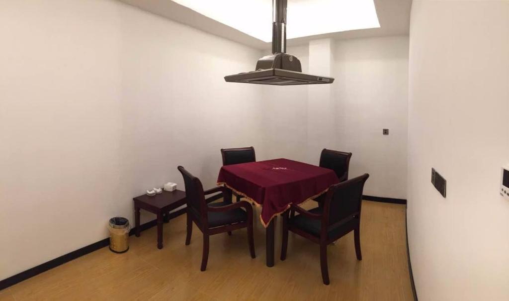 a dining room with a red table and chairs at 7Days Premium Huzhou Nanxun Ancient Town Branch in Huzhou
