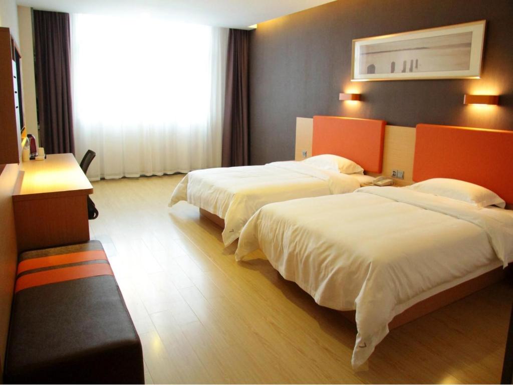 a hotel room with two beds and a window at 7Days Premium Leshan Qianwei Fengye Fortune Center Branch in Leshan