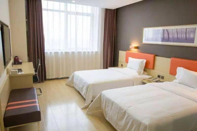 um quarto de hotel com duas camas e uma janela em 7Days Premium Beijing Fengtai South Road Subway Station Wumei Market Branch em Pequim