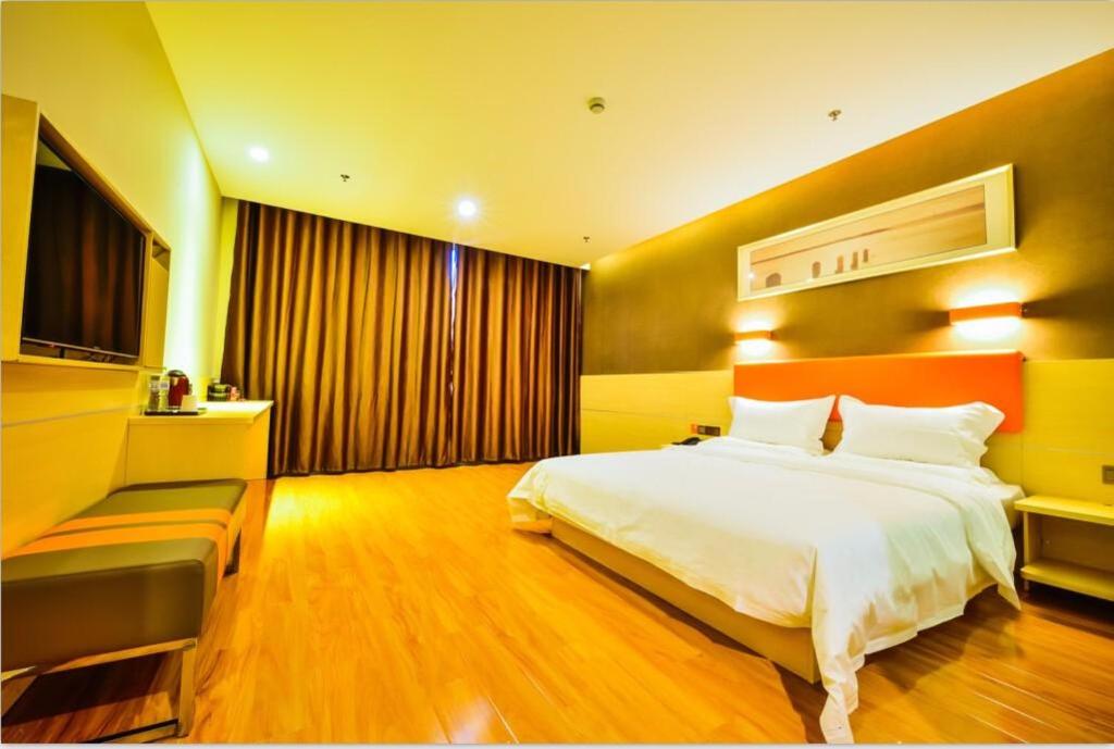 Habitación de hotel con cama y TV en 7Days Premium Shihezi Development Zone Branch, en Shihezi
