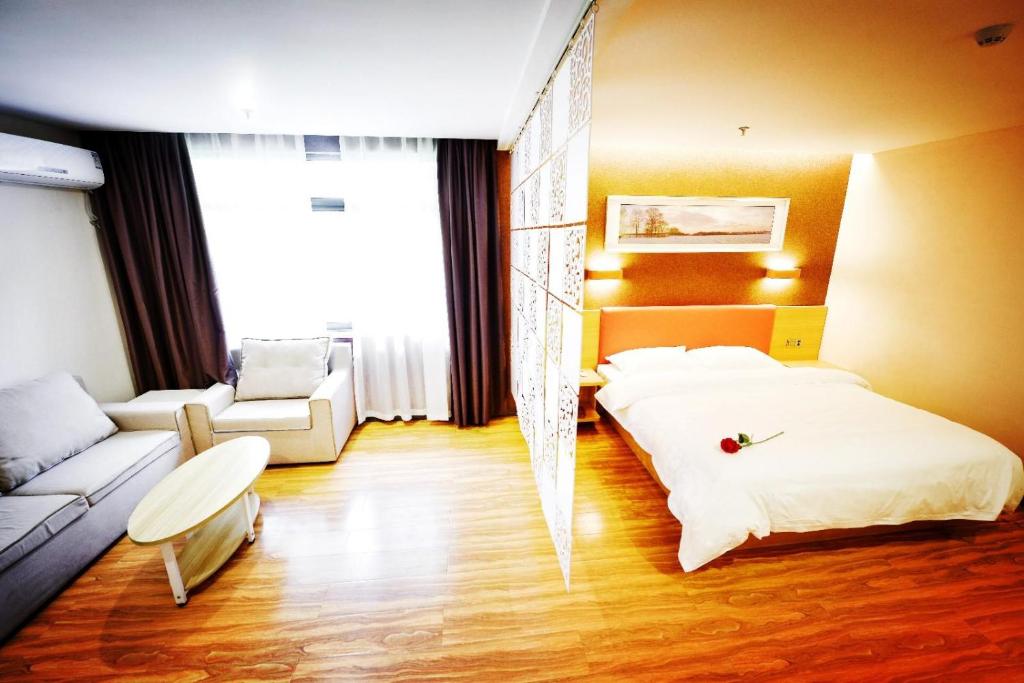 une chambre avec un lit et un canapé dans une pièce dans l'établissement 7Days Premium Chongqing Tongliang District Government Pedestrian Street Branch, à Tongliang