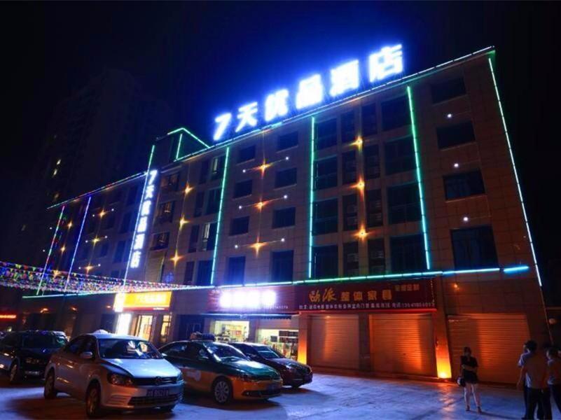 un edificio con coches estacionados en un estacionamiento por la noche en 7Days Premium Guang'an Chaoyang Avenue Branch, en Guang'an