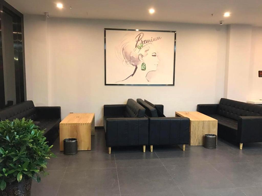 a living room with couches and a picture of a woman at 7 Days Premium Chongqing Jiangbei International Airport Branch in Chongqing