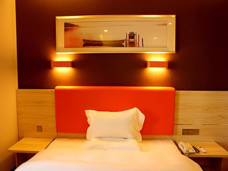 a bed with an orange headboard in a room at 7Days Premium Xi'an Lantian Lanxin Road Branch in Xi'an