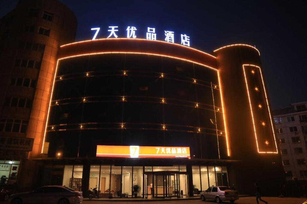 a building with a sign on top of it at night at 7Days Premium Yantai Penglai New Bus Station Branch in Penglai