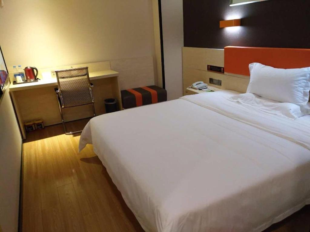 a large white bed in a hotel room at 7Days Premium Shenzhen Songgang Yanchuan Branch in Shenzhen