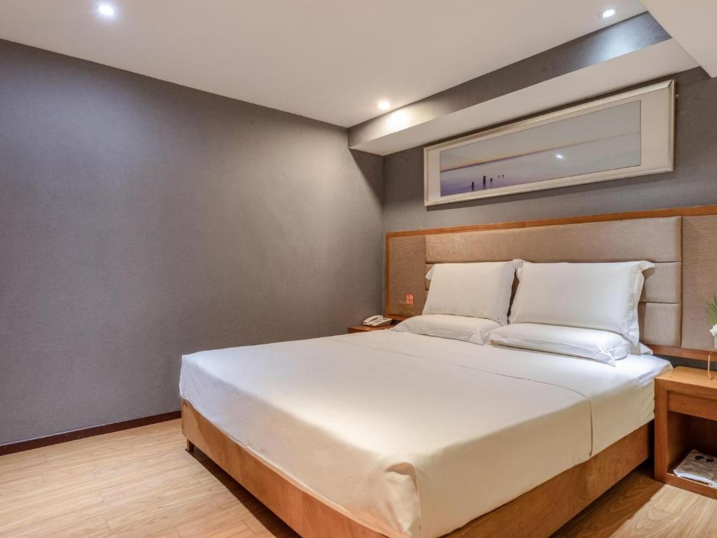 Un pat sau paturi într-o cameră la 7Days Premium Chongqing Guanyinqiao Pedestrian Street Light Rail Station Branch