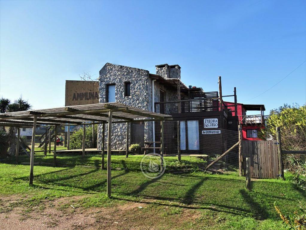 une vieille maison avec une clôture devant elle dans l'établissement Piedra y Cielo, à Punta del Diablo