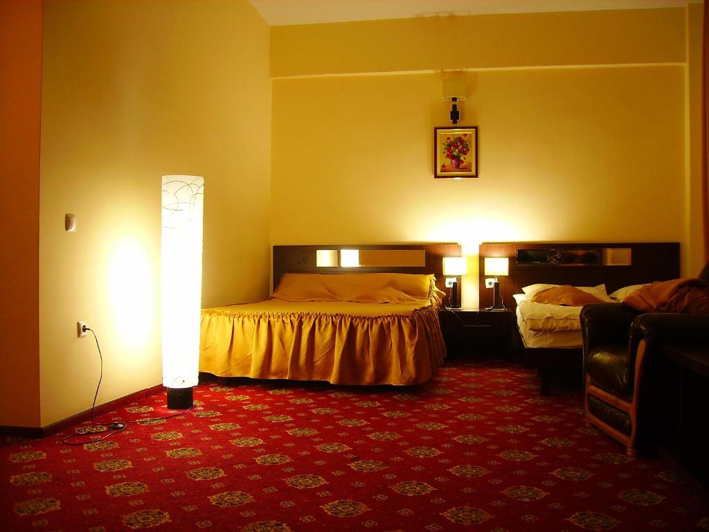 a hotel room with two beds and a red carpet at Hotel Magic GT Trivale in Piteşti