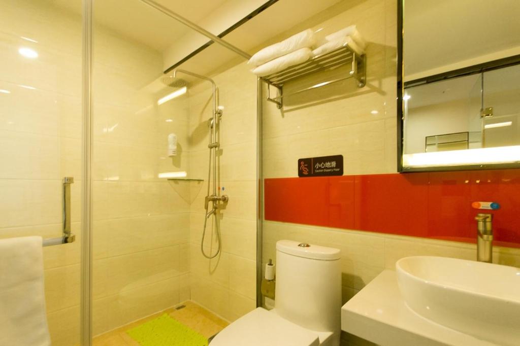 y baño con ducha, aseo y lavamanos. en 7Days Premium Zhengzhou Fangte Green Expo Park Branch, en Zhengzhou