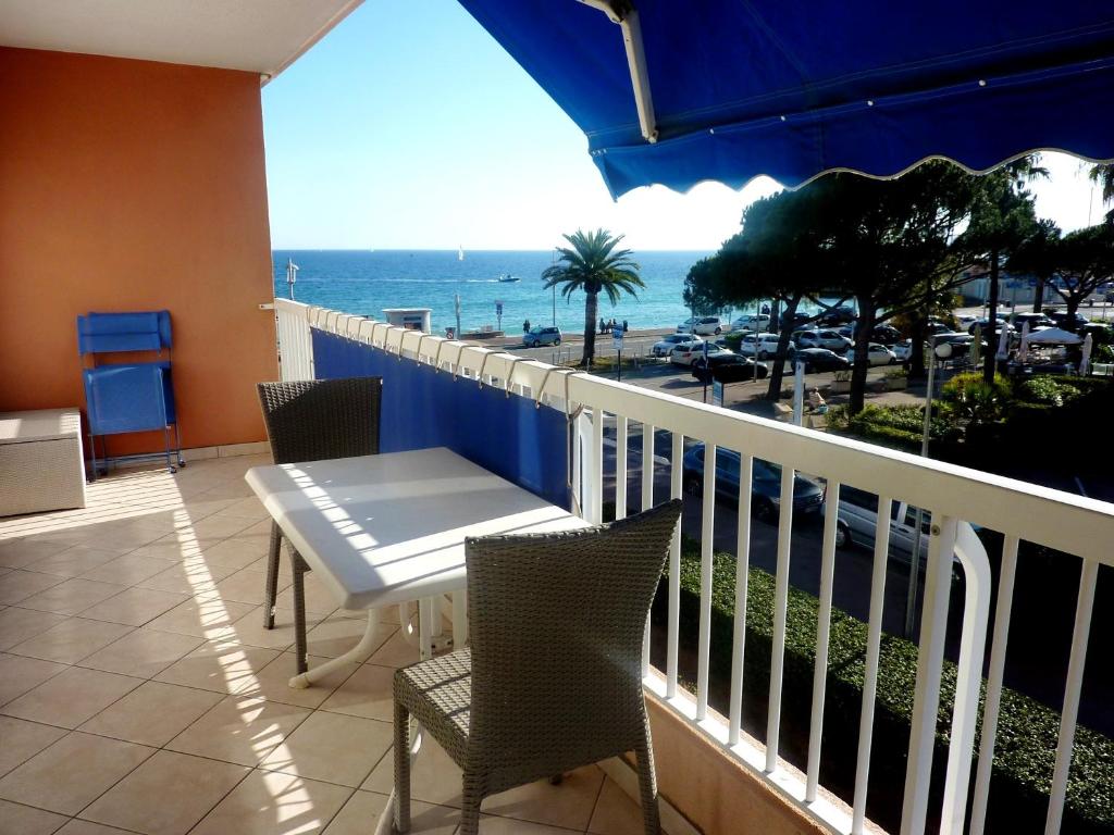 un balcon avec une table et des chaises et l'océan dans l'établissement Appartement moderne à Fréjus - 39 m² - Vue sur mer, à Fréjus
