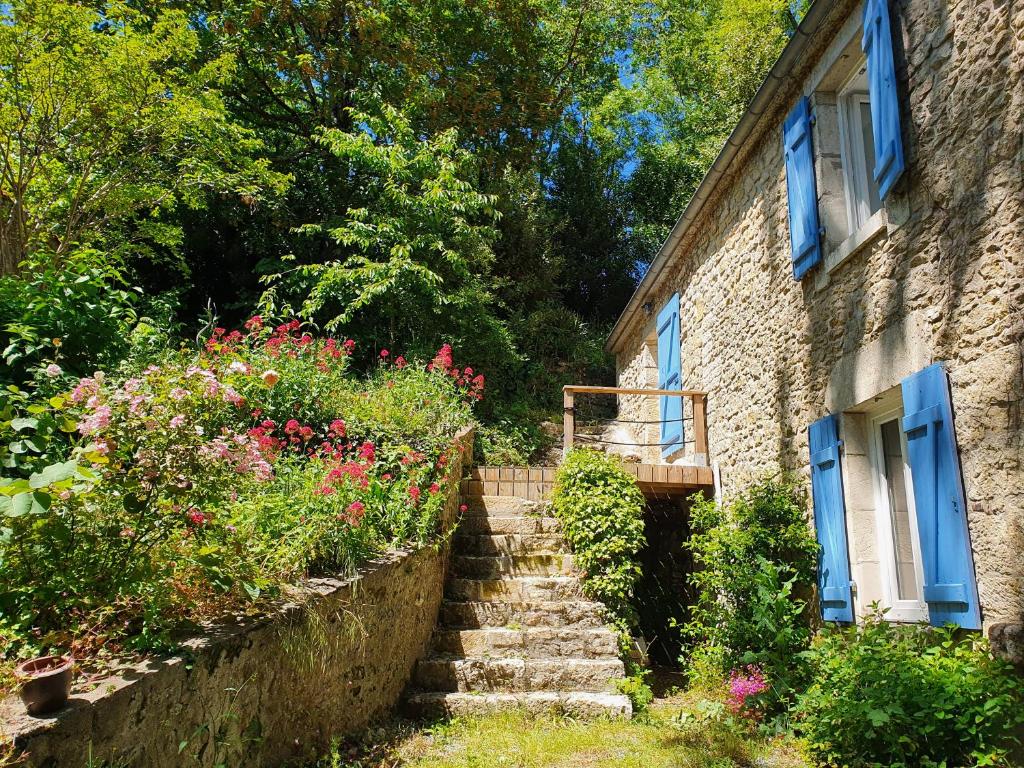 a stone house with stairs and flowers in front of it at La Petite Coquille in LʼOrbrie