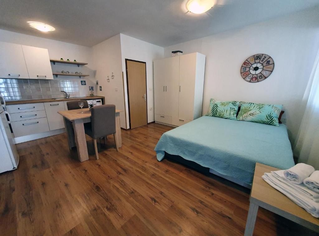 1 dormitorio con cama, mesa y cocina en Apartment Denis en Rovinj