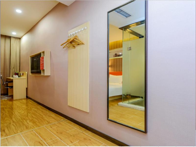 Zimmer mit einem Spiegel an der Wand und einem Zimmer mit einem Bett in der Unterkunft 7Days Premium Chongqing Jiefangbei Pedestrian Street Branch in Chongqing