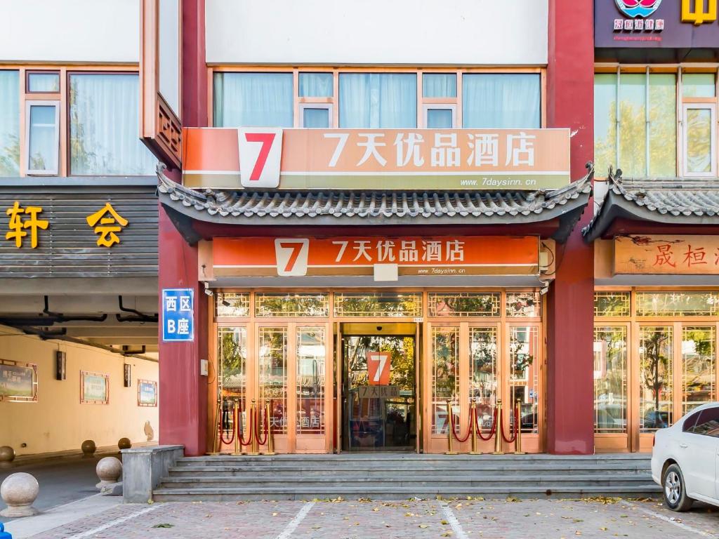 un bâtiment avec des panneaux à l'avant dans l'établissement 7Days Premium Beijing Happy Valley Wangsiyingqiao Branch, à Pékin