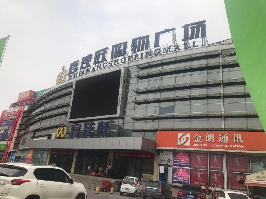 duży budynek z dużym znakiem na górze w obiekcie 7Days Premium Baoding Zhuozhou Development Zone Branch w mieście Zhangcun