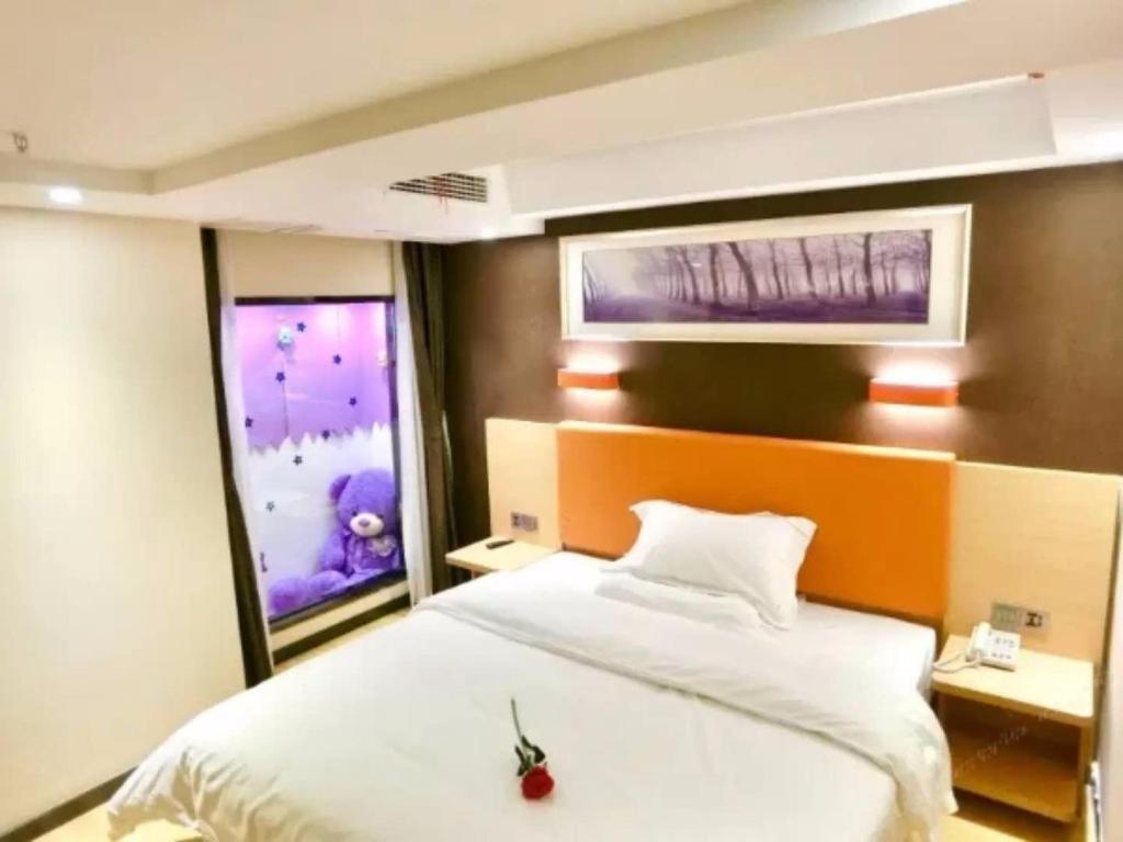 a bedroom with a bed and a window with a stuffed animal on it at 7Days Premium Chongqing Jiangbei International Airport Lushan Light Rail Station Branch in Chongqing